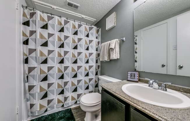 a bathroom with a shower and a sink and a toilet