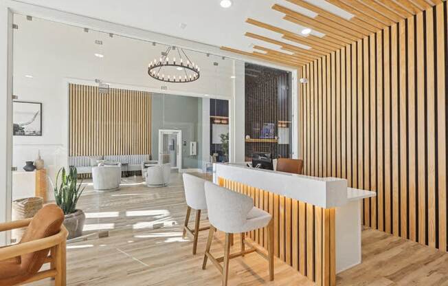 A reception area with a white counter and wooden chairs.