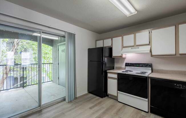 A kitchen with black appliances and white cabinets.