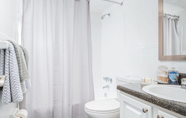 a white bathroom with a shower and a toilet  at The Park at Chesterfield Apartment Homes, Tampa