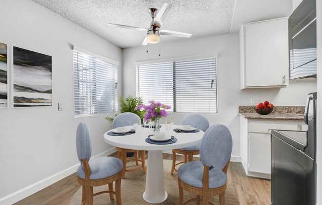 a dining room with a table and chairs and a ceiling fan