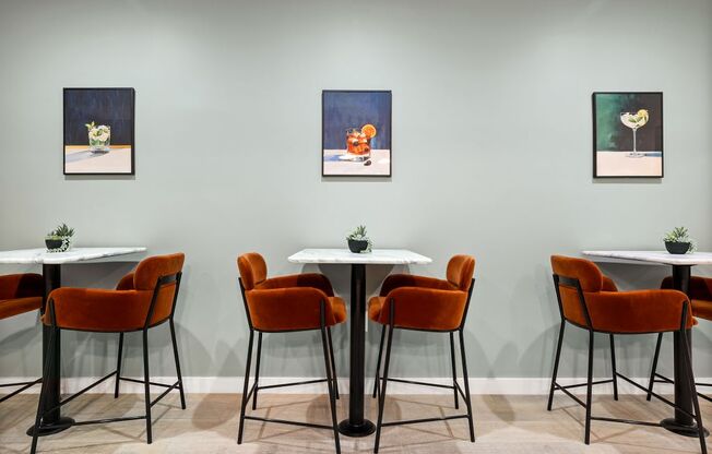 a dining room with tables and chairs and paintings on the wall