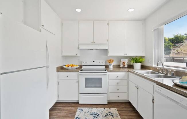 a white kitchen with white appliances and white cabinets