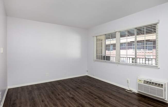 an empty living room with white walls and a window