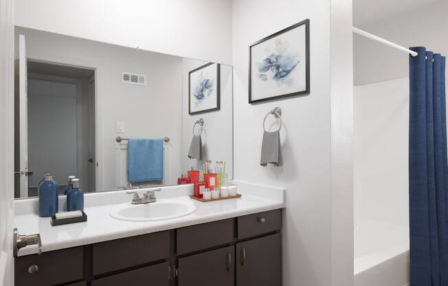 a bathroom with a sink and a mirror and a blue shower curtain