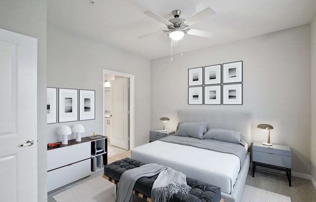 A bedroom with a bed, nightstands, and pictures on the wall.