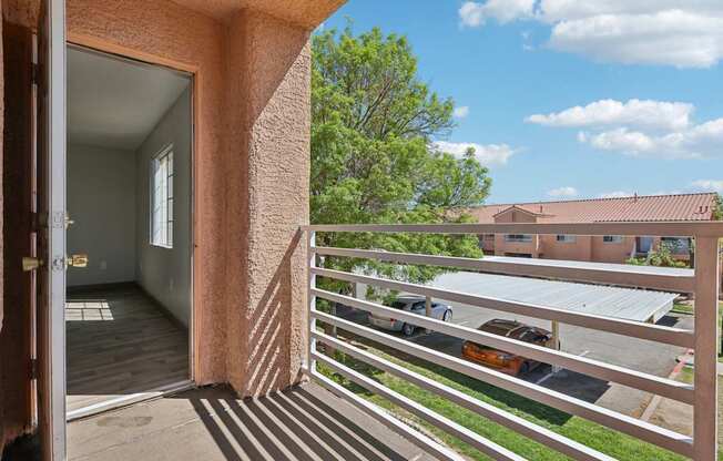 A view from a balcony looking out at a parking lot.