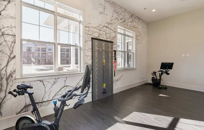 a workout room with exercise equipment and a large window
