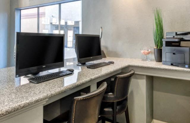 Ingleside Apartments Business Center with two computer screens and grey granite countertops and printer