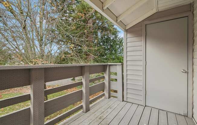 A wooden deck with a white door and a railing.