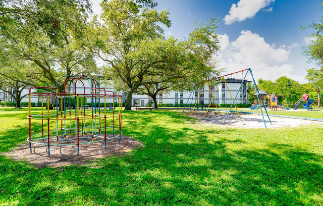 Playground with slides, swing sets and a climbing apparatus at Halcyon Apartments