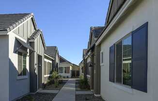 a row of houses with walkways between them and a blue sky