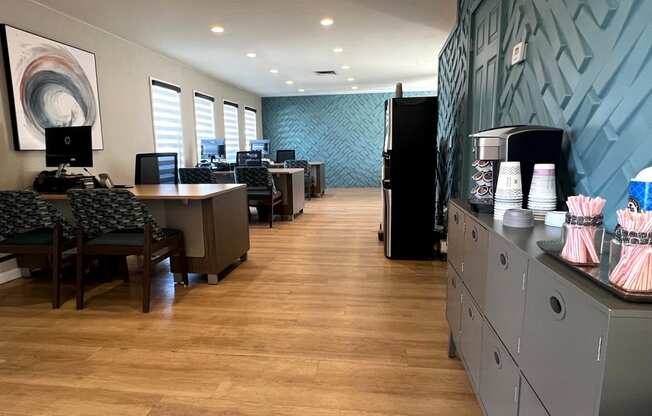an office with a blue accent wall and wood flooring