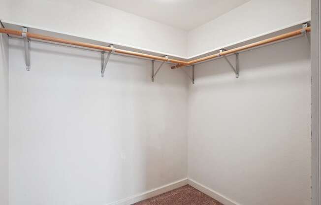 an empty room with a white wall and a curtain rod on the wall