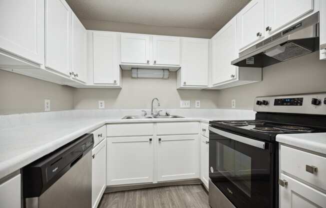 a kitchen with white cabinets and black appliances