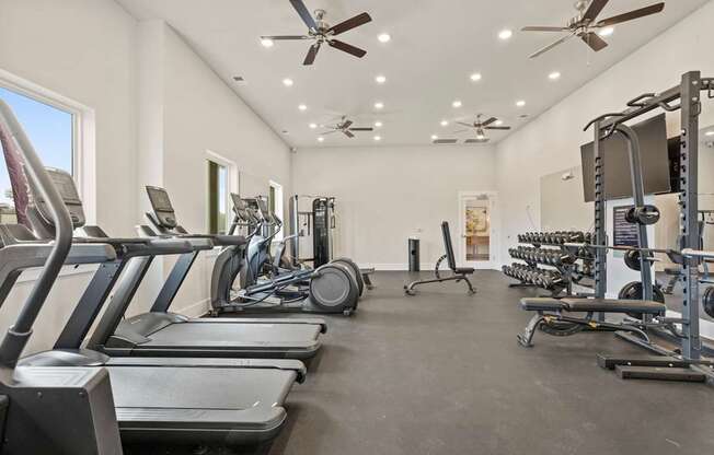 A spacious gym with treadmills, elliptical machines, and weightlifting equipment.