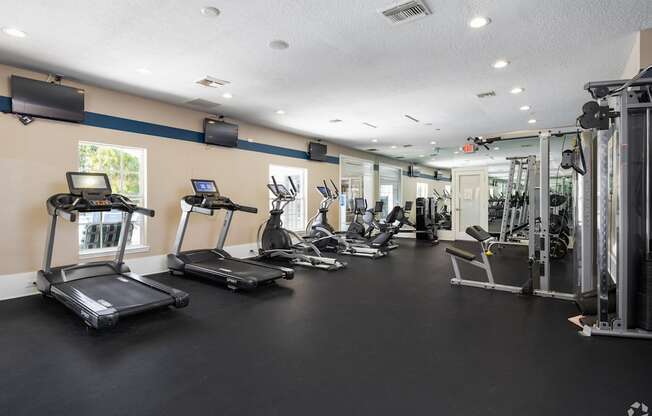 A gym with treadmills, exercise bikes, and other equipment.