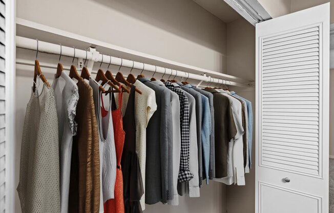 a closet filled with clothes hanging on a rack