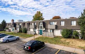 a parking lot with cars in front of an apartment building