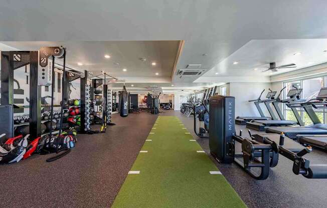 a spacious fitness center with cardio machines and weights