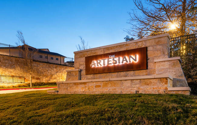 the sign for the arisian at night in front of a stone building