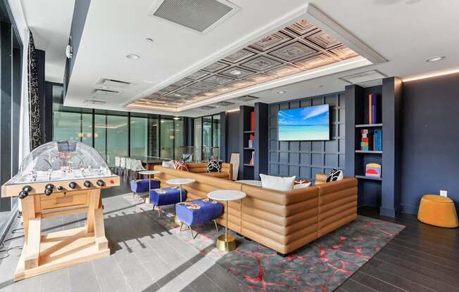 A room with a foosball table and a couch.