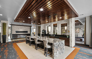 a large kitchen with a marble counter top and a long table with chairs