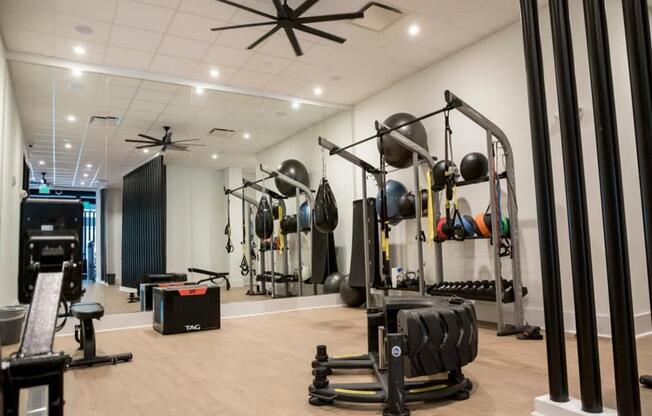 a gym with weights and other exercise equipment at Flats at West Broad Village, Virginia