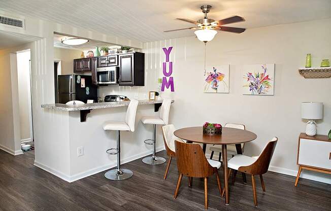 A kitchen with a dining table and chairs.