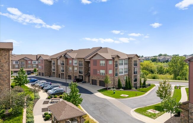 A large apartment complex with a parking lot in front.