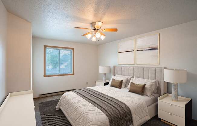 the master bedroom has a large bed and a ceiling fan. Fargo, ND Westview Towers Apartments