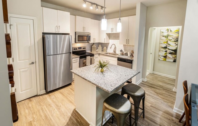 a kitchen with stainless steel appliances and a marble counter top