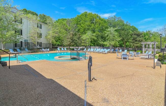 our apartments have a large pool with chairs and trees at Reserve of Jackson Apartment Homes, Jackson, Mississippi