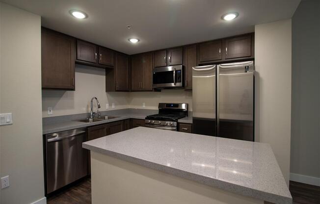 a kitchen with a large island and stainless steel appliances at Loma Villas Apartments in San Bernardino, CA