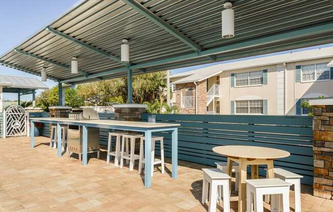 a patio with tables and chairs and a pergola