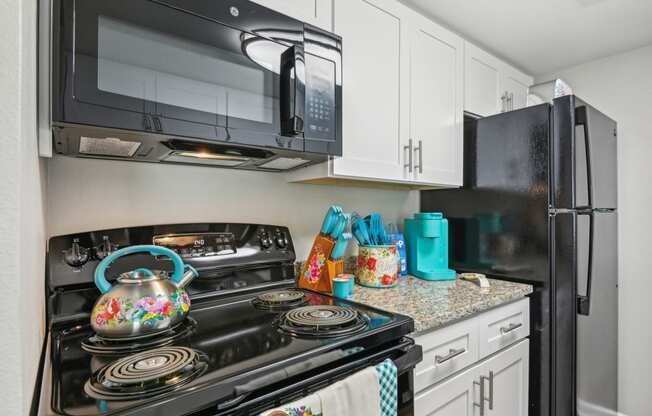 a kitchen with a stove and microwave and a refrigerator