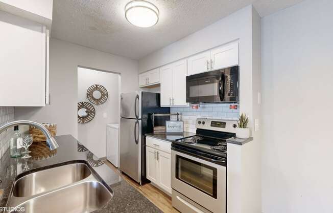 a kitchen with stainless steel appliances and white cabinets