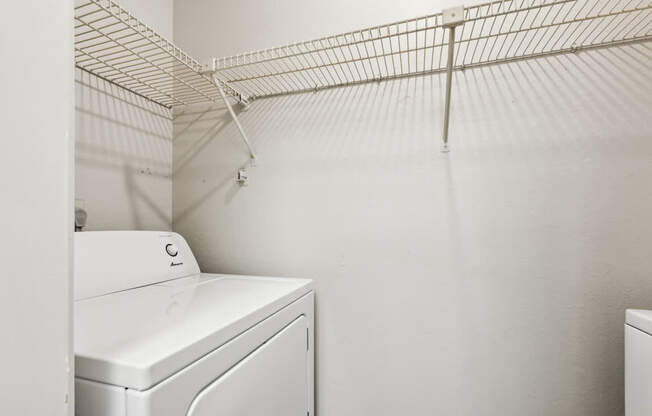 A white washing machine sits in a laundry room.