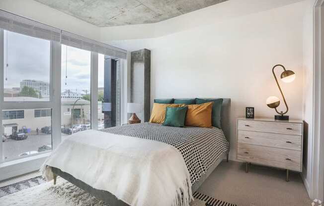 A bedroom with a large bed and a view of the city.