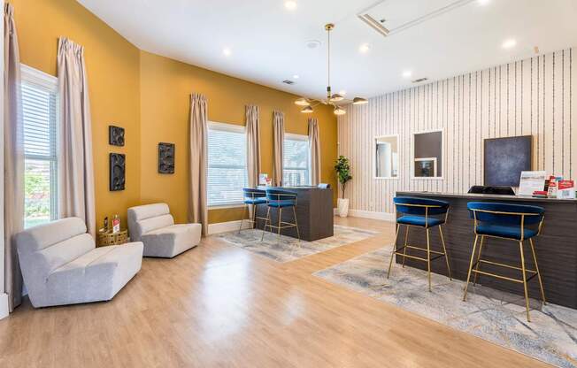 A living room with a bar area and two chairs.