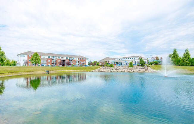 a pond with a fountain in front of a building