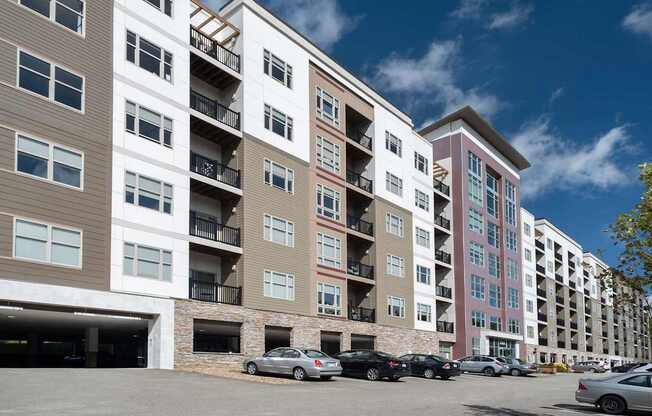 A multi-story apartment building with a parking lot at Cosmopolitan Apartments, Pittsburgh, PA