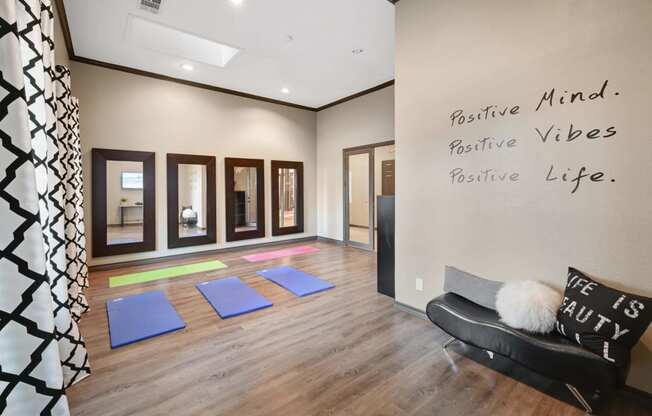 a yoga room with blue yoga mats and a black chair