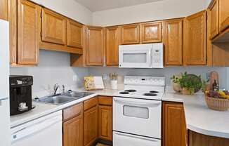 a kitchen with white appliances and wooden cabinets