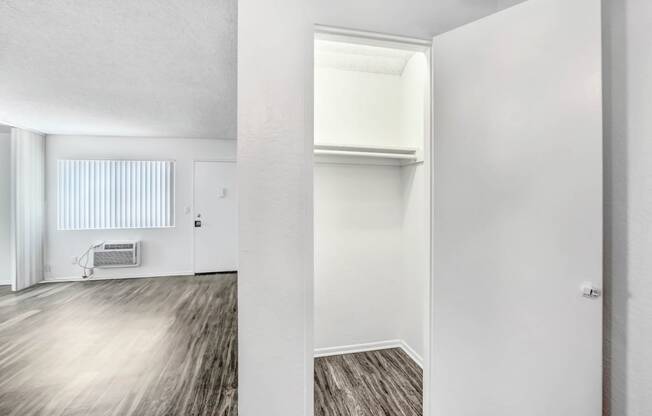 an empty living room with white walls and wood flooring