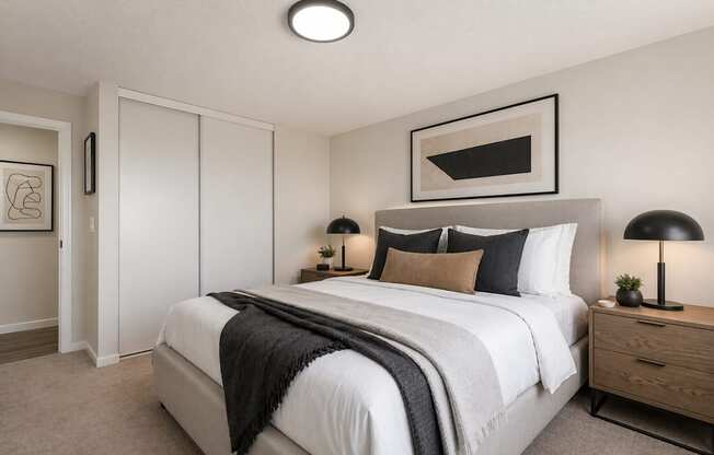 A bedroom with a large bed and a painting above it.