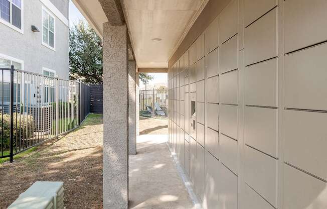 a walkway leading to a building with a fence and a bench
