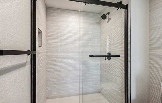 A white bathroom with a glass shower door.