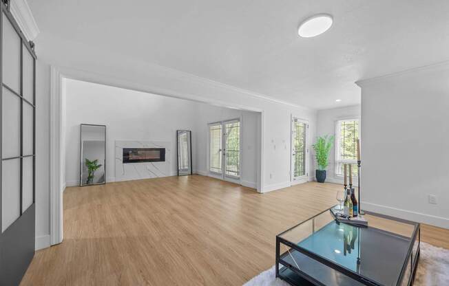 A modern living room with a glass coffee table in the center.