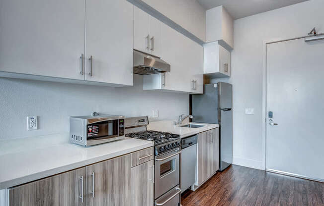 A kitchen with white cabinets and a stainless steel refrigerator.